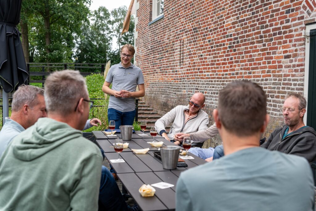 Biersommelier van DeBiermeneer staat aan de kop van de tafel en vertelt over het bier